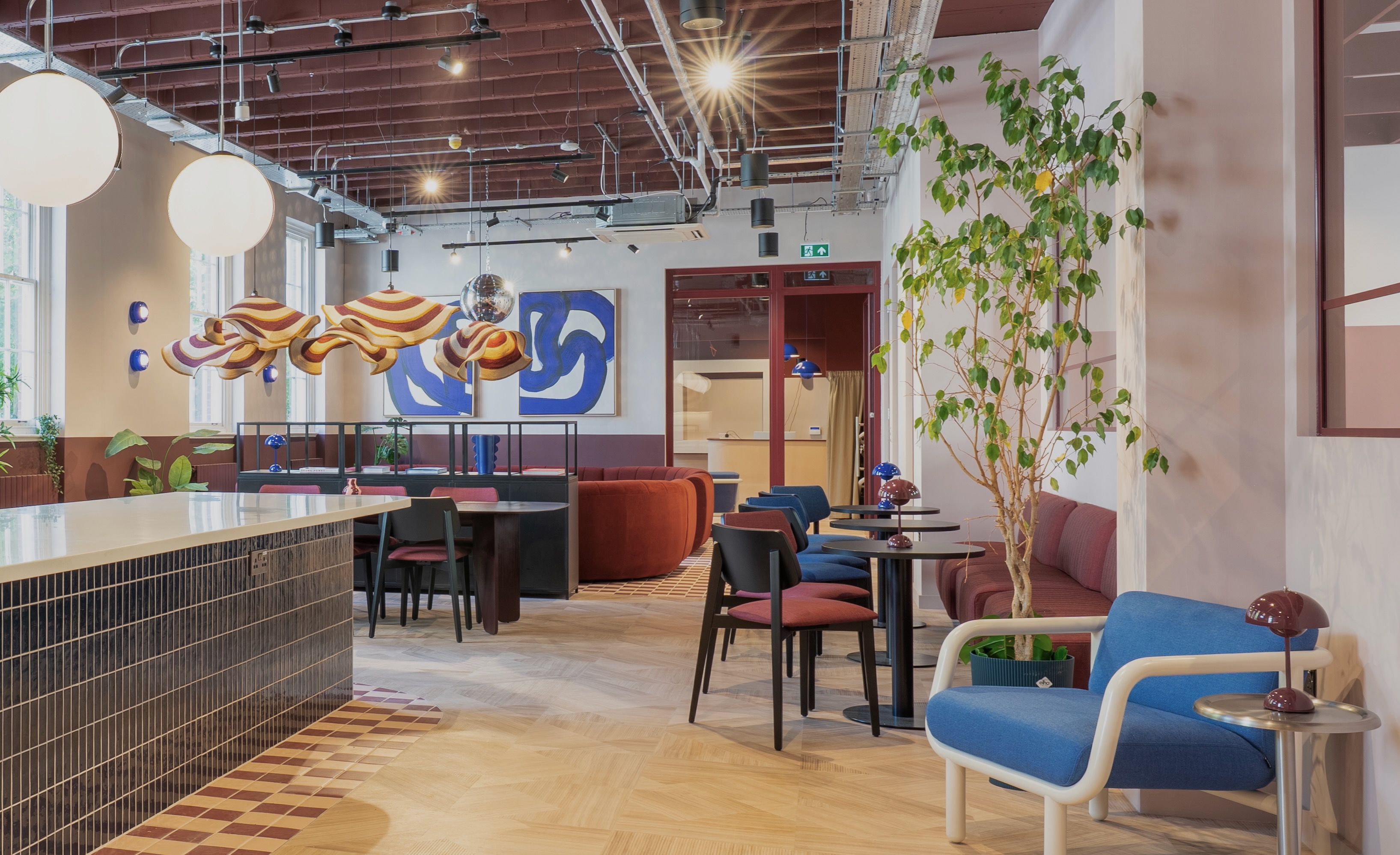 Bristol social space with terracotta sofa and colourful pendant lighting
